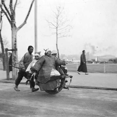 手推着独轮车的一家三口