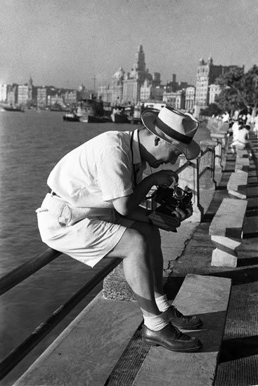 1947年，留美归来的规划师钟耀华在外滩摆弄手中的相机。