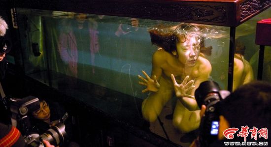 苏紫紫作品拍摄现场，裸体的她在鱼缸里挣扎，寓意都市愈来愈逼仄的空间。