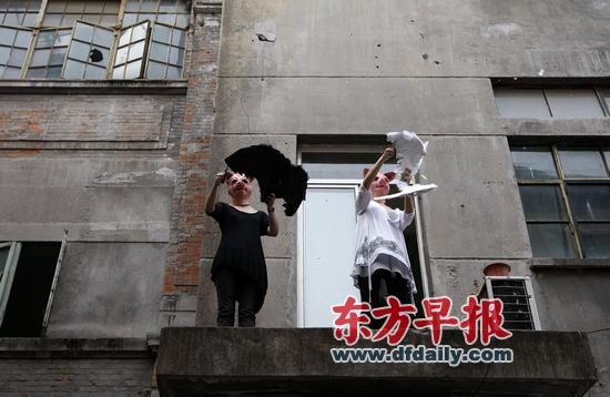 艺术家站在高处，抛洒从翅膀上剪下的羽毛。 早报记者 赵昀 图