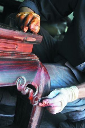工人正在打磨、补平红木家具。