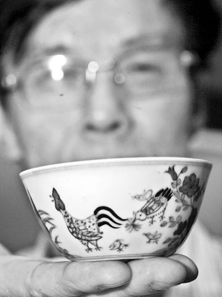 任经文在展示他收藏的鸡缸杯。