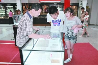 詹洪阁 (左一)向参观人员介绍展品。