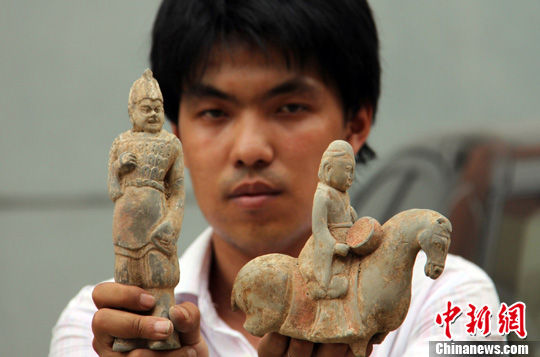 河北永年县文保所工作人员展示骑马乐伎陶俑和兵陶俑。中新社发 马继前 摄