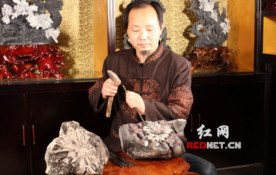 佘军正在雕刻菊花石作品