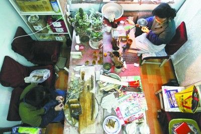 李世美师傅（左）和张国茹师傅（右）分别忙着自己的工作，各自的工具摆在手边，喜欢花的张师傅在桌子一端摆满了虎皮兰，而李师傅则喜欢听收音机，大家忙着手头的工作顾不上聊天，只有一台老式收音机还在讲个不停。