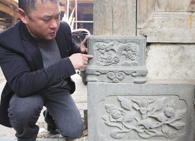 溪坦村村委会主任王连明在介绍王氏大宗祠精美的石刻龙图案。