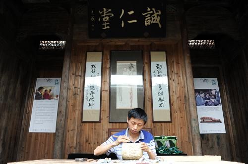 徽派建筑内，民间艺人张红贵在雕刻竹雕。