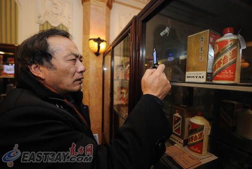图片说明：市民用手机拍下展示中的茅台酒。