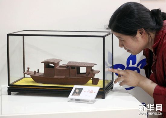 参观者在欣赏紫砂雕塑作品“红船驶过90载”。