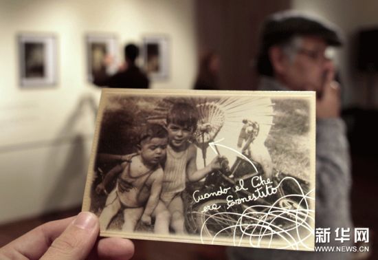 6月15日，一位参观者手拿一张反映古巴革命英雄切?格瓦拉童年生活的照片的复制品。