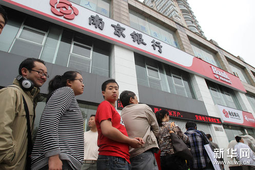 6月16日，市民在江苏南通一银行门口排队，准备购买中国共产党成立90周年普通纪念币和2011年贺岁普通纪念币。新华网图片 许丛军 摄