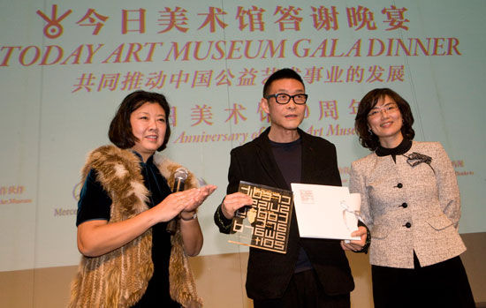 2.今日美术馆战略发展理事胡安女士（左）和瑞信北京代表处首席代表李蓓兰女士（右）为艺术家汪建伟颁奖