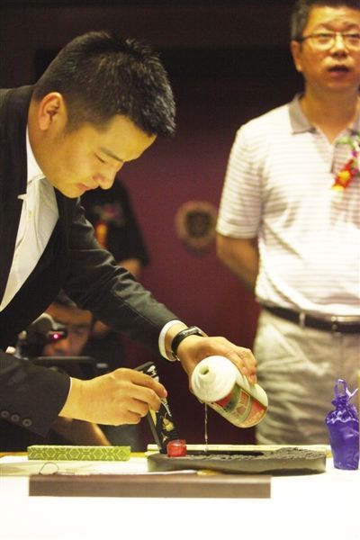 国香馆老酒会所内，工作人员用价值5万元的78年的茅台酒研墨，供嘉宾题字。