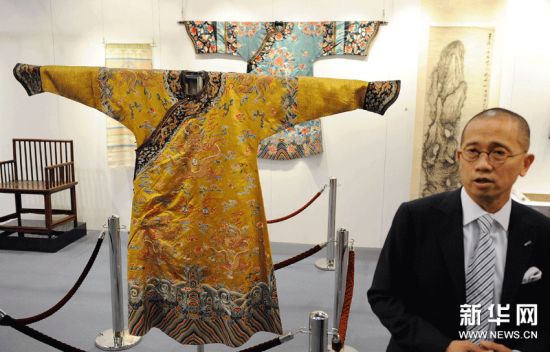 9月30日，工作人员在媒体预展上展示清乾隆御制明黄缎地绣云蝠花卉金龙纹吉服袍。该拍品估价150万至200万港元。