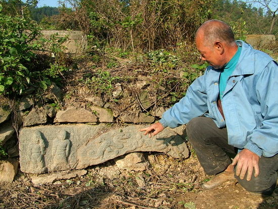 一块石头上雕有两尊身着疑似唐朝服装的佛像，旁边是二龙戏珠的图案。