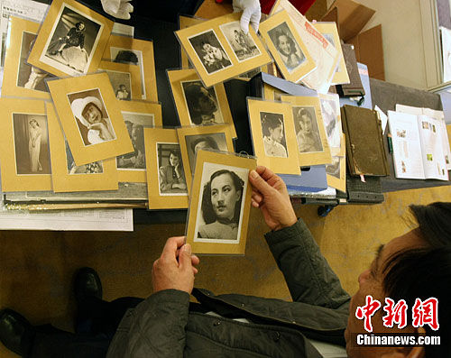 11月9日，观众在北京华辰秋拍预展上翻看周璇的老照片。中新社发 张浩 摄