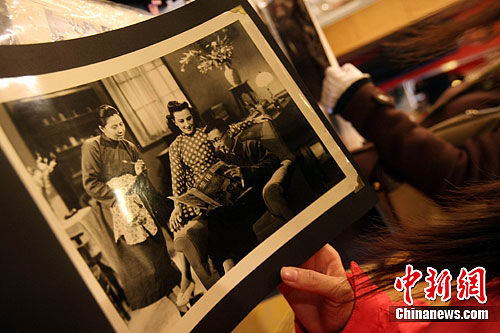 11月9日，观众在北京华辰秋拍预展上翻看周璇的老照片。中新社发 张浩 摄