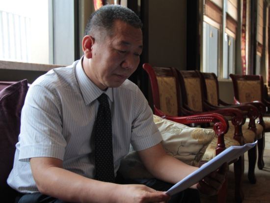 郭庆祥正在仔细查看判决书