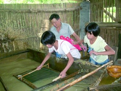 中学生正在体验“捞纸”工序。 