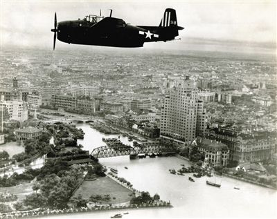 外白渡桥和苏州河 拍摄时间：1945年9月8日 黄浦江上空，照片自东向西拍摄。苏州河口的建筑清晰可见，外白渡桥北侧的百老汇大厦上还看得到“兴亚”的字样，这是上海沦陷后日军强行更改的名字。乍浦路桥和外白渡桥间的码头上停着很多中式帆船；照片左侧可见外滩公园、新天安堂、邮政总局和新亚大酒店的尖塔；远处的虹口区还没有太多高楼，如今则大不一样了。