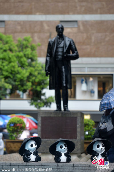 1600纸熊猫香港中环皇后像广场“快闪” 下雨天戴蓑笠帽萌爆游人。Bergen L/东方IC